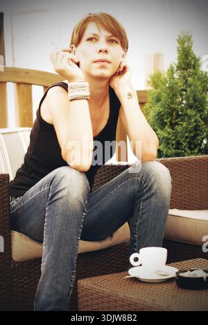 A beautiful young woman having a cup of hot coffee Stock Photo