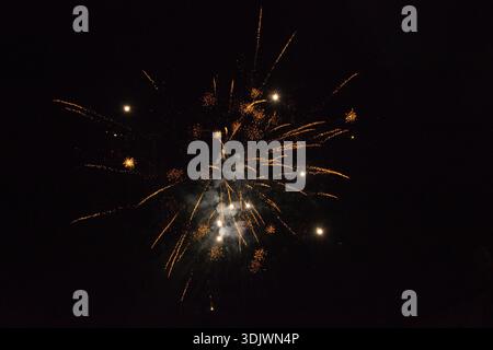 Fireworks explosion in the dark night sky, colorful light burst against black background, festive and celebration concept. Stock Photo
