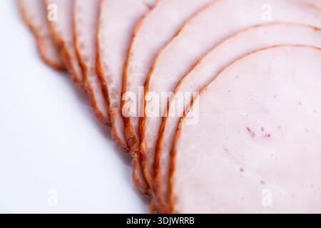 Gourmet sandwich ham layer closeup, thin even slices with smoked rim, evokes premium lunch prep and chef ingredient selection for artisan sandwich men Stock Photo
