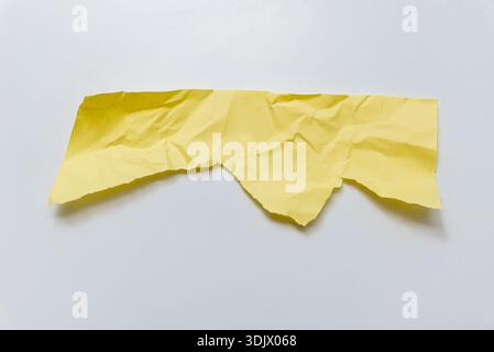 Crumpled old yellow paper on isolated white background, old textured sheets with torn edges and copy space for text Stock Photo