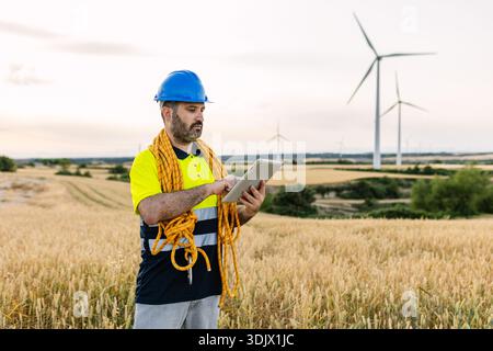 Engineer using tablet checking wind turbine farm Stock Photo