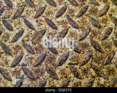 Industrial weathered metal floor with heavy orange rust and raised tread pattern. Shot at Ecseri ut, Budapest, this high-detail steel plate texture Stock Photo