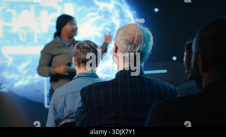 Senior investor listening to speaker presenting AI brain high tech with data visualization and deep learning demos. IT and business forum to obtain funding and investing at convention. Stock Photo