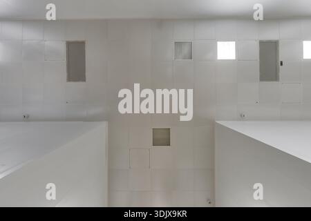 view straight up at cassette suspended ceiling with square fluorescent lights or halogen spots lamps  in a work area or hallway with ventilation Stock Photo