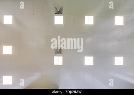 view straight up at cassette suspended ceiling with square fluorescent lights or halogen spots lamps  in a work area or hallway with ventilation Stock Photo