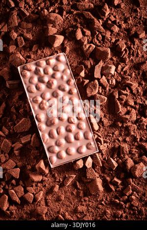 Sweet hazelnut chocolate with chocolate topping and nuts. Hazelnut chocolate on cocoa background. Stock Photo