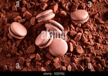 Handmade chocolate macaroons made of chocolate and meringue. Chocolate macaroons on cocoa background. Stock Photo