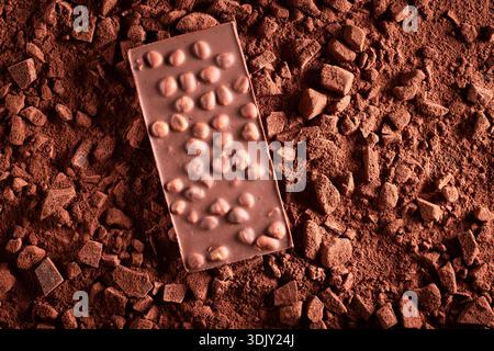 Sweet hazelnut chocolate made of nuts and chocolate. Hazelnut chocolate on cocoa background. Stock Photo