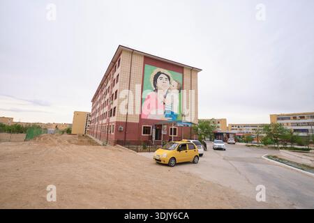 A mural of a mother and child on the side of an apartment building. In Zarafshan, Navoi Region, Uzbekistan. Stock Photo