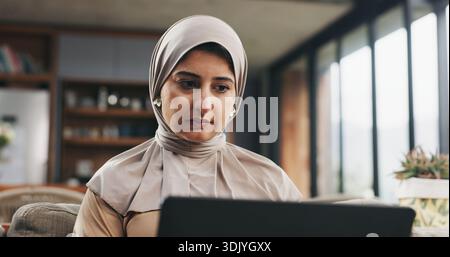 Muslim woman, laptop and reading in home for learning, online Quran course or Arabic language studying. Education, computer or person with hijab for Stock Photo