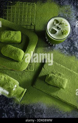 Iced matcha green tea latte with matcha mochi cakes on dark stone background, Top view of iced matcha green tea in glass with powder and mochi Stock Photo