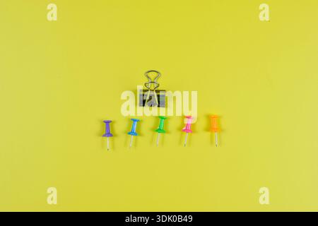 Colorful push pins on yellow-green surface highlight organization, planning, and visual contrast in office or educational settings. Stock Photo