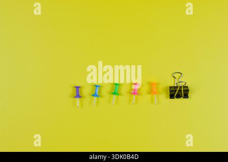 Colorful push pins on yellow-green surface highlight organization, planning, and visual contrast in office or educational settings. Stock Photo