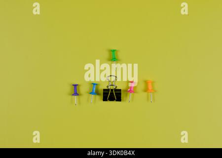 Colorful push pins on yellow-green surface highlight organization, planning, and visual contrast in office or educational settings. Stock Photo
