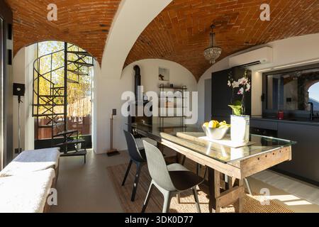 Inside a small room with a table, two chairs and a kitchen. A confined space, but very elegant. Basically a modern kitchen with lots of antique featur Stock Photo