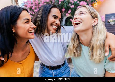 Multiracial young female friends laughing together outdoors Stock Photo