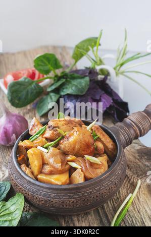 potato vegetable chicken stew. a dish of stewed root vegetables served in a decorative earthenware dish. Stock Photo
