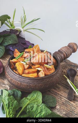 potato vegetable chicken stew. a dish of stewed root vegetables served in a decorative earthenware dish. Stock Photo