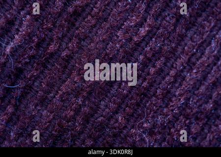 Extreme close up of maroon wool knit material. Showing detailed textile patterns and soft fabric fibers for fashion or craft background. Stock Photo