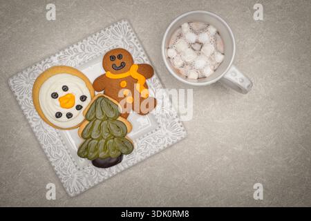Winter Themed Cookies on a White Plate with Hot Chocolate on a  Marble Table Stock Photo