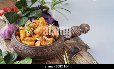 potato vegetable chicken stew. a dish of stewed root vegetables served in a decorative earthenware dish. Stock Photo