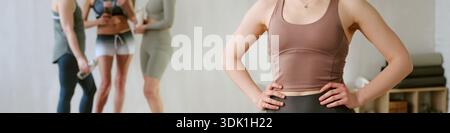Young Woman Standing Confidently in Fitness Studio with Group Training Stock Photo