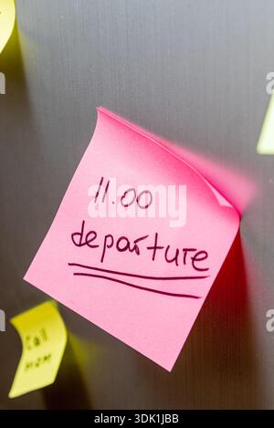 Reminder sticker glued to the refrigerator door to catch the plane departure at 11 a.m. Stock Photo