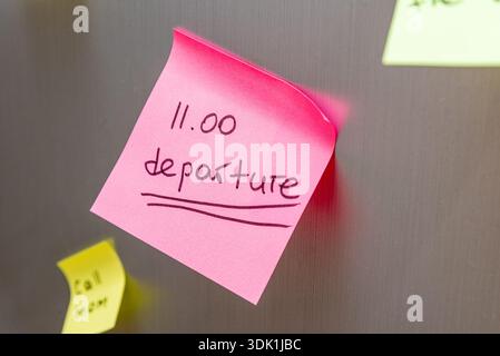 Reminder sticker glued to the refrigerator door to catch the plane departure at 11 a.m. Stock Photo