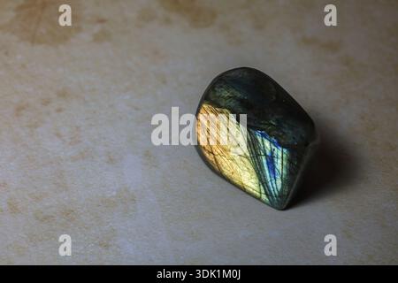 Close-up image of a polished labradorite gemstone displaying natural iridescent colors and reflective mineral patterns. Stock Photo