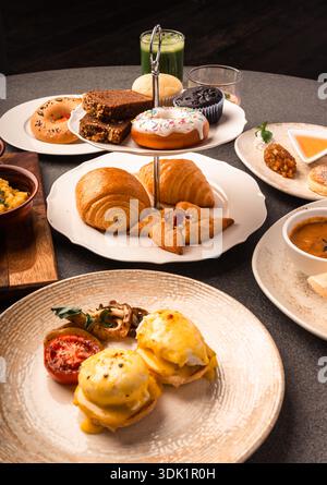 Elaborate Breakfast Spread with Eggs Benedict and Pastries Stock Photo