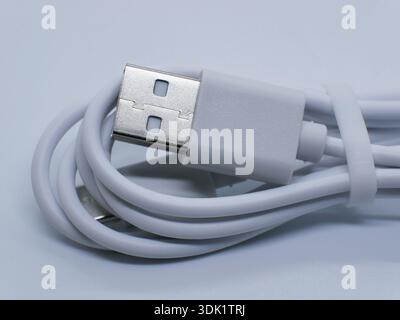 Close-up of white USB cable with connector on clean white background. Charging and data transfer concept for smartphones, gadgets, accessories, techno Stock Photo
