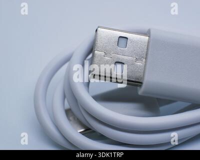 Close-up of white USB cable with connector on clean white background. Charging and data transfer concept for smartphones, gadgets, accessories, techno Stock Photo