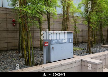 Fire equipment in large building in Singapore City. Fire hose and alarm button. Fire safety infrastructure. Stock Photo