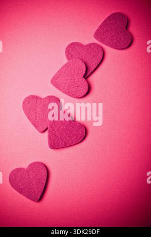 Pink felt hearts arranged on a soft background, romantic love concept for Valentine’s Day and relationships Stock Photo