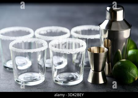 Bar accessories and ingredients for prepared cocktail Margarita on a black table. Stock Photo