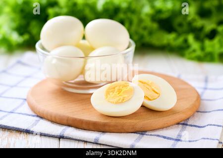 boiled chicken eggs peeled and cut in half on a light kitchen table. Stock Photo