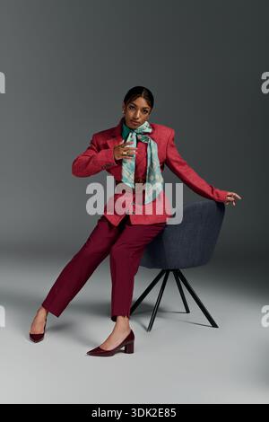 Stylish young woman poses confidently in smart casual attire in a contemporary studio space. Stock Photo