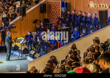 The singer Ahmet Özhan performs with a traditional orchestra and choir during the Şeb-i Arus ceremony at the Mevlana Kültür Merkezi in Karatay, Konya, Turkey, a venue that holds up to 3,000 people. A conductor leads the ensemble. Şeb-i Arus is the annual festival marking the death anniversary (17 December) of the mystic poet Rumi (1207–1273), founder of the Mevlevi order, celebrated as a spiritual union with God. Stock Photo