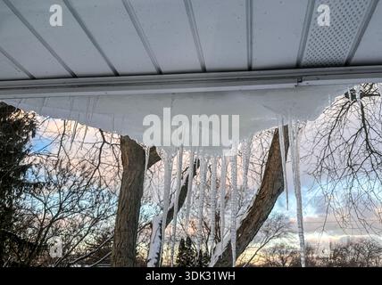 Large icicles hanging from a roof in winter Stock Photo