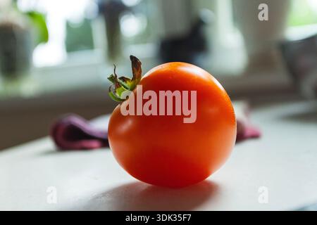 The red tomato is on the counter Stock Photo