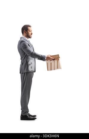 Full length profile shot of a businessman holding a cardboard box isolated on white background Stock Photo