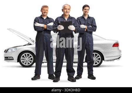 Team of mechanics posing in front of a silver car isolated on white background Stock Photo