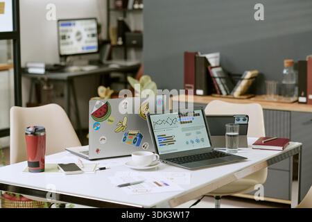 Modern Office Workspace Featuring Laptops Displaying Data Analytics Graphs Stock Photo