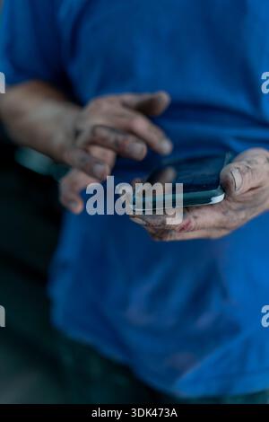 mechanic's hands using a cell phone Stock Photo
