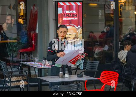 TGI Friday's restaurant staff member preparing to serve customers at the outdoor seating area of the chain restaurant in Athens, Greece. Promotion for Stock Photo