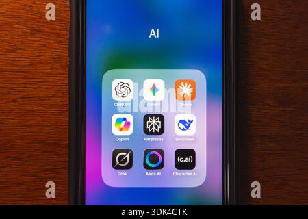 Smartphone screen showing a folder labeled "AI" containing various chatbot and assistant apps like ChatGPT, Claude, Gemini, and Grok. Stock Photo