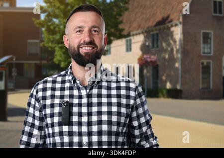 Man with hidden spy camera in his pocket on city street outdoors Stock Photo