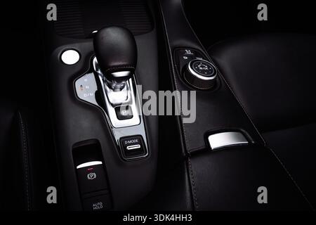 Close-up view of a modern car center console with automatic gear selector, electronic parking brake, and drive mode control dial. Premium automotive i Stock Photo
