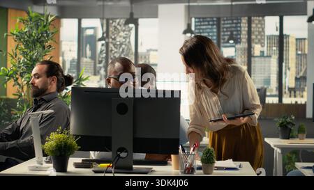Business colleagues using computers to analyze insights and performance metrics, making projections and data visualization. Employees share reports to improve corporate development. Stock Photo