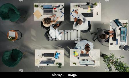 Top down view of business colleagues using computers to analyze insights and performance metrics, making projections and data visualization. Reports for corporate development. Stock Photo